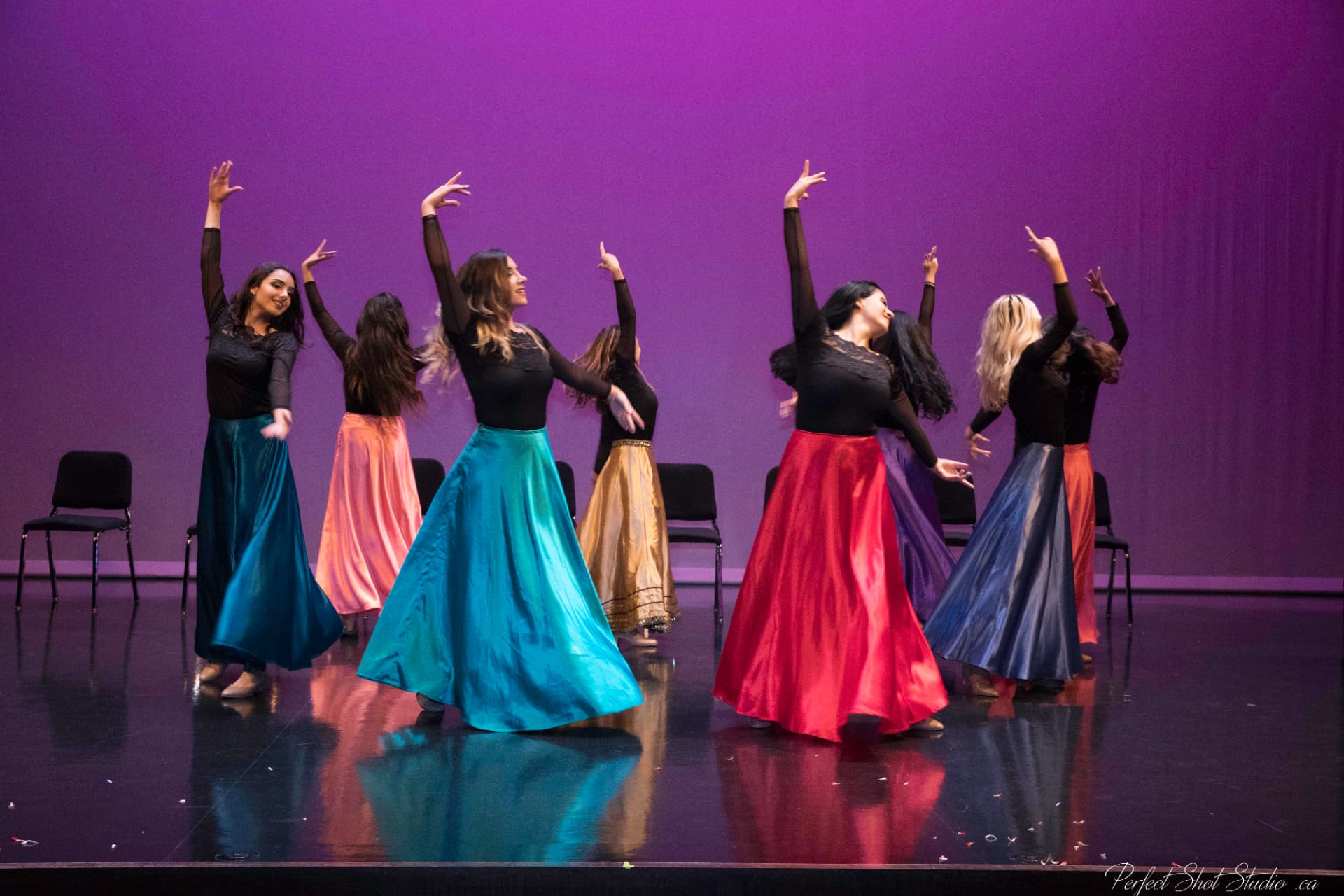 Dancers in coloured skirts on stage