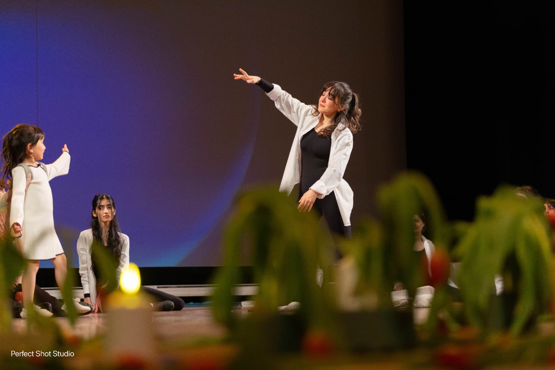 A dancer reaching out during a company performance